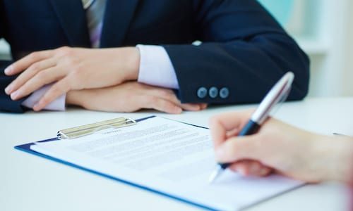 Hands of business woman signing the contract document with pen on desk. selective focus image on sign a contract. Just hands over the table. Signing a franchise agreement